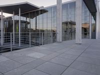 a glass and aluminum building with a staircase near a building entrance and a reflection in the glass