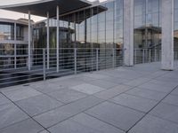 a glass and aluminum building with a staircase near a building entrance and a reflection in the glass