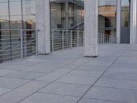 a glass and aluminum building with a staircase near a building entrance and a reflection in the glass