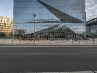 a glass facade of a building across from another structure and bus stop in front of it