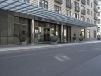 the building has windows and several potted plants outside of it as well as on the side walk