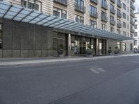 the building has windows and several potted plants outside of it as well as on the side walk