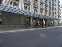 the building has windows and several potted plants outside of it as well as on the side walk