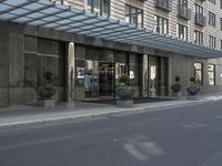 the building has windows and several potted plants outside of it as well as on the side walk