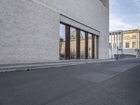 a bike is parked in front of a large building with glass doors on the wall