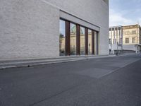 a bike is parked in front of a large building with glass doors on the wall