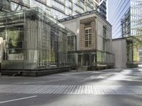 an industrial looking building with a glass roof next to a tree in a city square