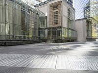 an industrial looking building with a glass roof next to a tree in a city square