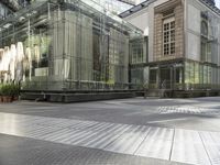 an industrial looking building with a glass roof next to a tree in a city square