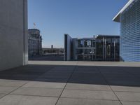 the walkway is concrete and has glass walls and glass doors on it's sides