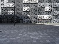 a person standing outside an artistic building covered in geometric shapes and objects in the city