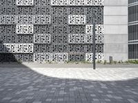 a person standing outside an artistic building covered in geometric shapes and objects in the city