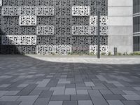 a person standing outside an artistic building covered in geometric shapes and objects in the city