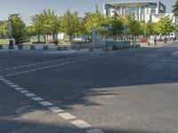 the two lane paved road looks rather like it is empty except there are trees in front