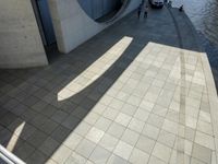 the shadow of a skateboarder in a bathroom on the tiled floor outside a bathtub