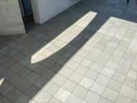 the shadow of a skateboarder in a bathroom on the tiled floor outside a bathtub