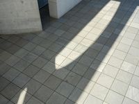 the shadow of a skateboarder in a bathroom on the tiled floor outside a bathtub