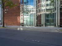 a building with glass on the top and a man riding a bike near it near a street