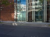 a building with glass on the top and a man riding a bike near it near a street