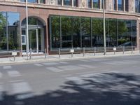 a black car is stopped in front of an empty store front building near some trees