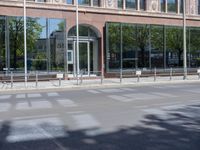 a black car is stopped in front of an empty store front building near some trees
