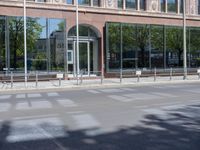 a black car is stopped in front of an empty store front building near some trees