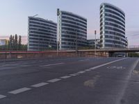 two buildings with curved windows next to a highway in the city of london, england