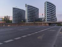 two buildings with curved windows next to a highway in the city of london, england