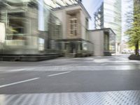 the road has a brick block and a tall building next to it with buildings in the background