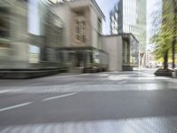 the road has a brick block and a tall building next to it with buildings in the background