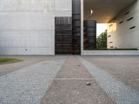 a door and two tall metal storage containers on a road near an outdoor plaza on a bright day