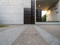 a door and two tall metal storage containers on a road near an outdoor plaza on a bright day