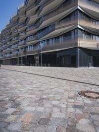 a brick building with glass windows and sidewalk leading to it and a black fire hydrant