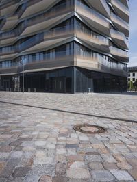 a brick building with glass windows and sidewalk leading to it and a black fire hydrant