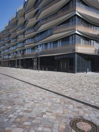a brick building with glass windows and sidewalk leading to it and a black fire hydrant