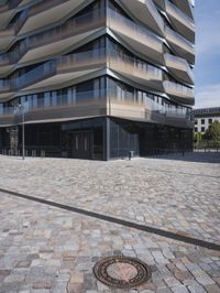 a brick building with glass windows and sidewalk leading to it and a black fire hydrant