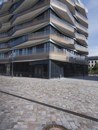 a brick building with glass windows and sidewalk leading to it and a black fire hydrant