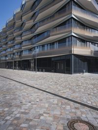 a brick building with glass windows and sidewalk leading to it and a black fire hydrant