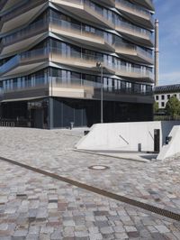 a brick building with glass windows and sidewalk leading to it and a black fire hydrant