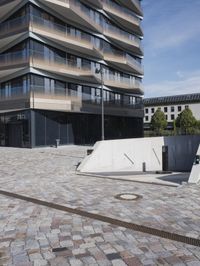 a brick building with glass windows and sidewalk leading to it and a black fire hydrant
