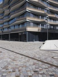 a brick building with glass windows and sidewalk leading to it and a black fire hydrant
