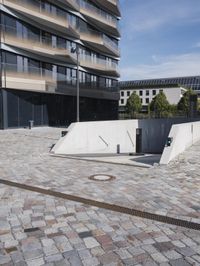 a brick building with glass windows and sidewalk leading to it and a black fire hydrant
