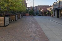 a very small brick lined street in a big town center area with buildings along both sides