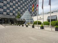 there is an entrance to a large building with flags in front of it on a walkway