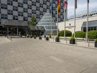 there is an entrance to a large building with flags in front of it on a walkway