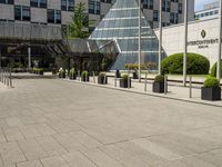 there is an entrance to a large building with flags in front of it on a walkway