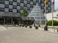 there is an entrance to a large building with flags in front of it on a walkway