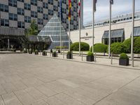 there is an entrance to a large building with flags in front of it on a walkway