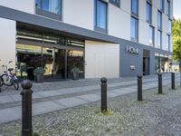 a gray office building with large windows and the name ottello in front of it