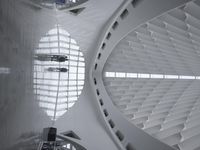 the roof of a building with multiple windows is white in color and has metal rods